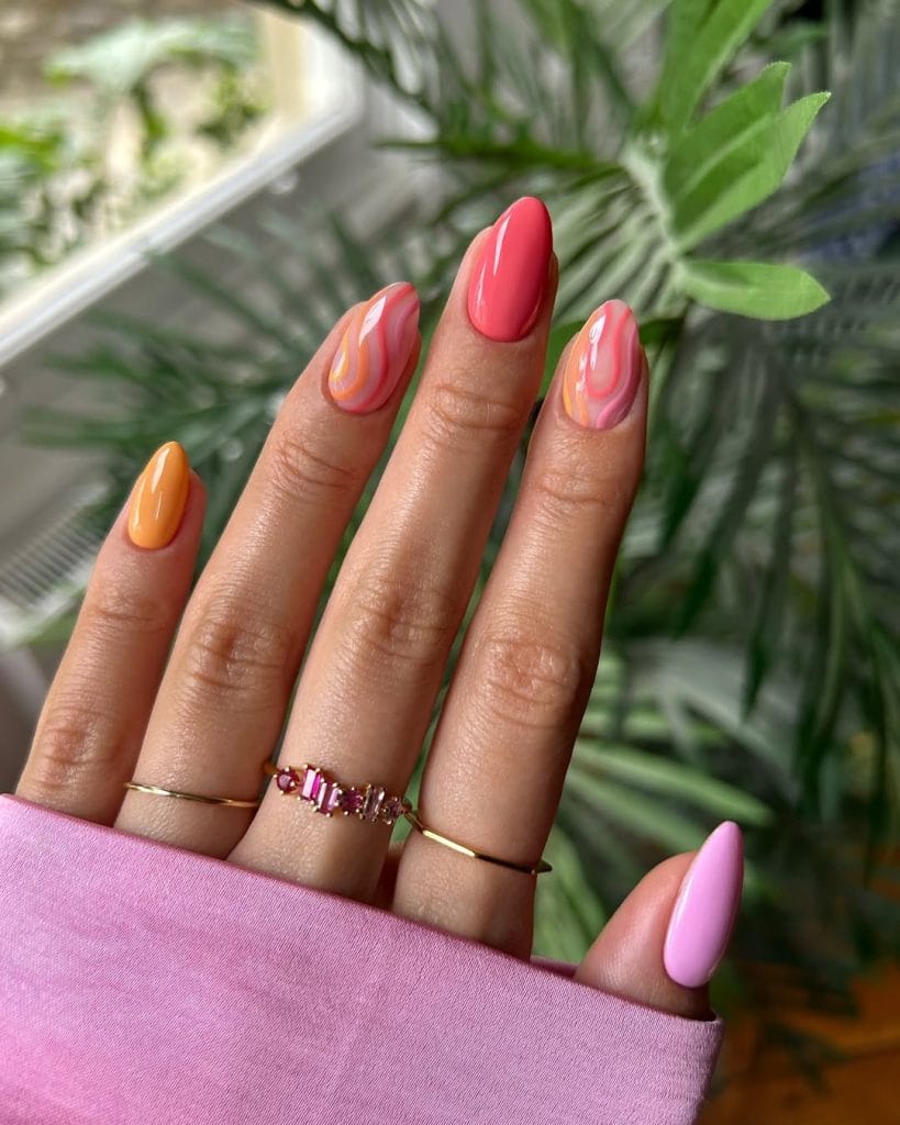 almond vacation nails with psychedelic swirl patterns in coral orange and pink colors