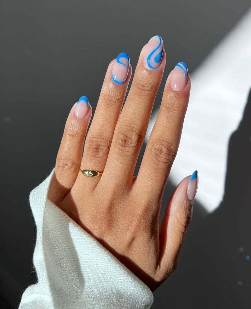  oval vacation nails with nude base and blue wave French tip design
