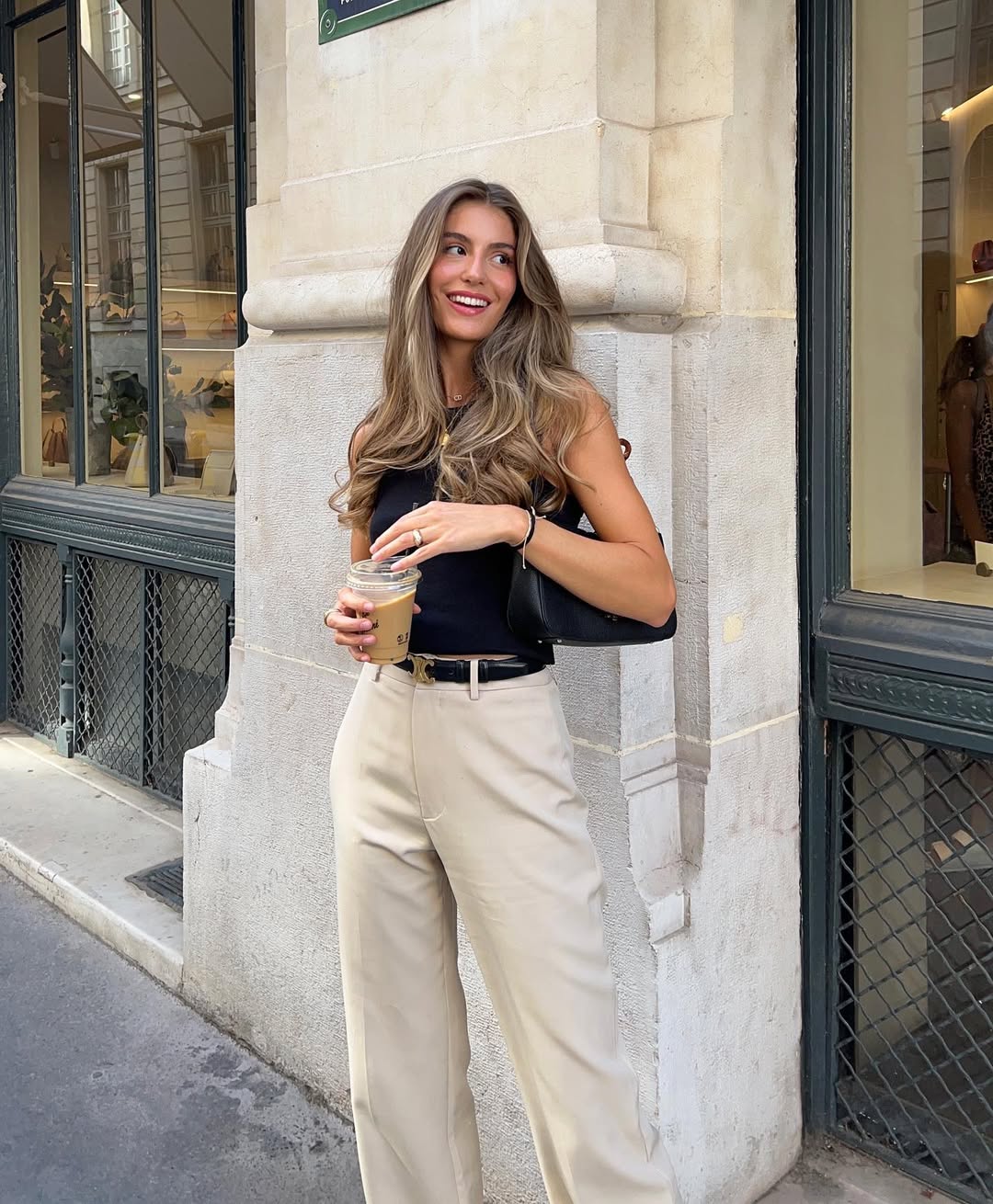 Classic summer work outfit with navy fitted tank top, beige wide-leg trousers, black leather belt and minimalist gold jewelry