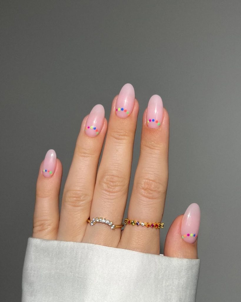 Elegant almond shaped June nails with soft pink base and colorful rainbow micro dots design