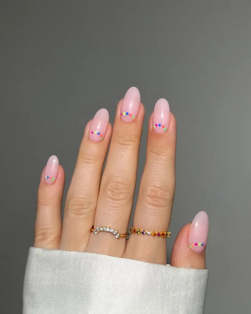 Elegant almond shaped June nails with soft pink base and colorful rainbow micro dots design