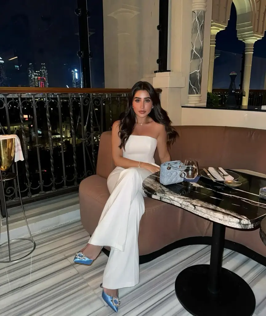 Elegant summer date night outfit with white strapless top, high-waisted cream wide-leg trousers, blue satin crystal-embellished heels and quilted baby blue handbag
