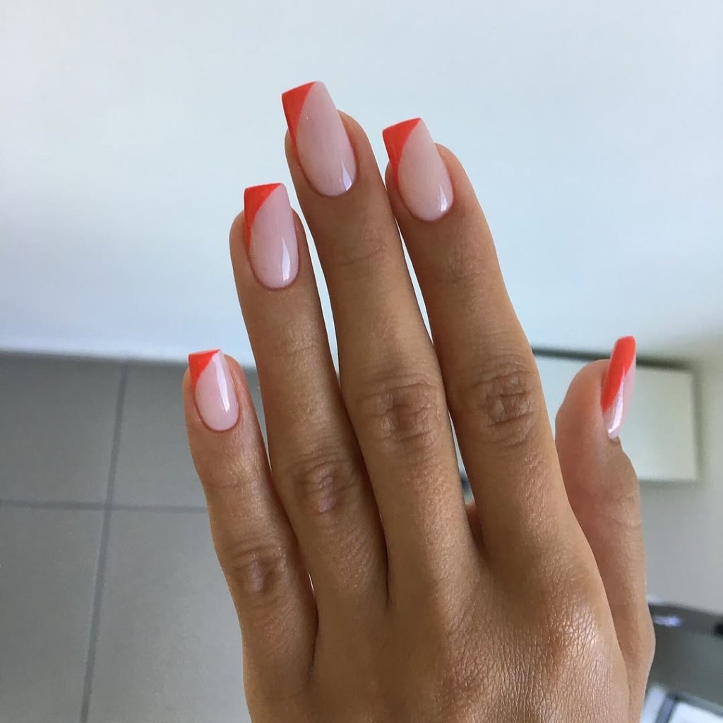Square shaped sheer pink nails with bright poppy-red triangular side accents at tips