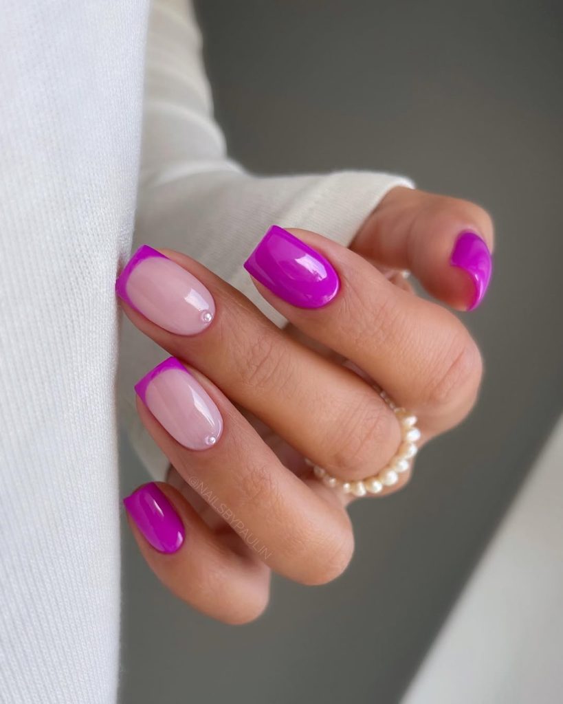 Short nails with alternating neon magenta and milky pink with French tips and pearl accents for feminine summer style
