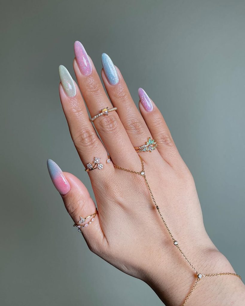 Almond shaped summer nails with iridescent sparkly pastel polish in pink, blue and opal tones
