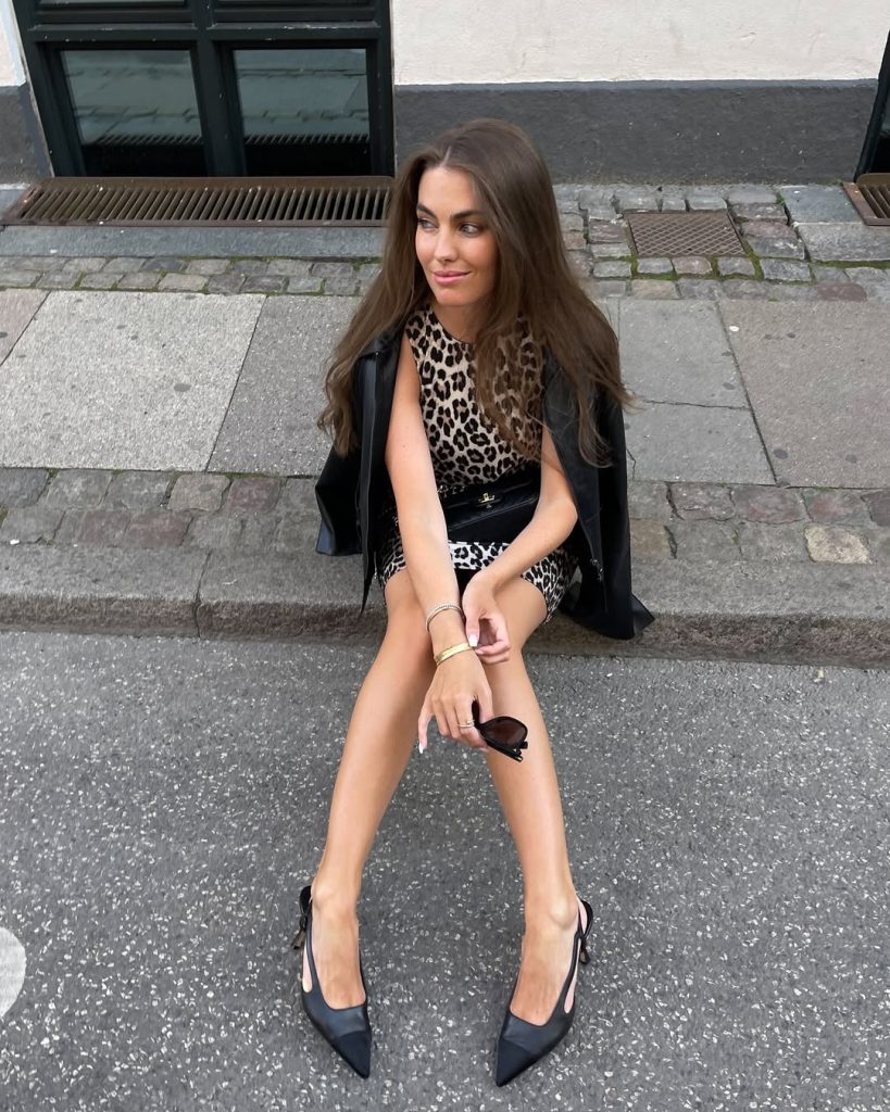 Night out outfit with leopard print mini dress, black leather jacket, black waist belt and black pointed slingback heels