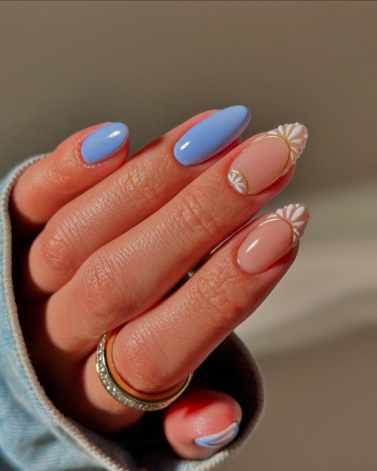 oval vacation nails with blue and nude skittles design and white daisy nail art accents