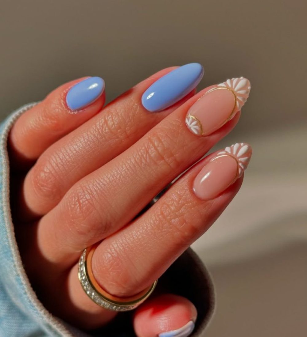 oval vacation nails with blue and nude skittles design and white daisy nail art accents