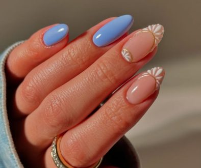 oval vacation nails with blue and nude skittles design and white daisy nail art accents
