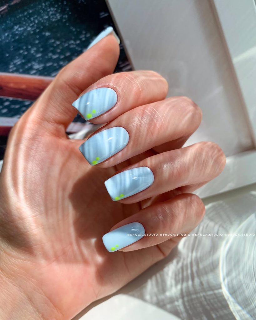 Classy June nails with square shape featuring baby blue polish with tiny neon green flower corner accents