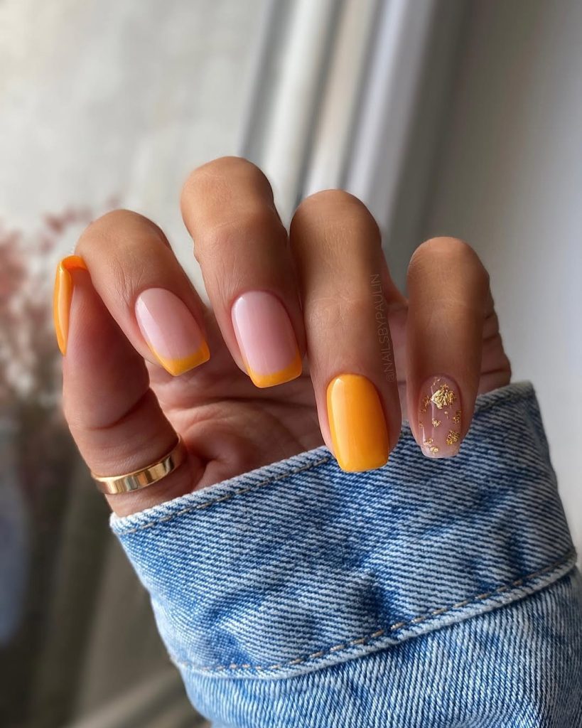 Square summer nails with pink base and marigold French tips, one full orange nail and one gold flake accent nail
