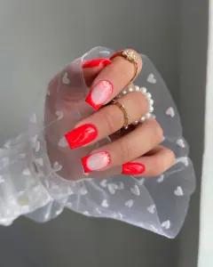 Long square neon coral nails with natural base accent nails and curved details and glitter