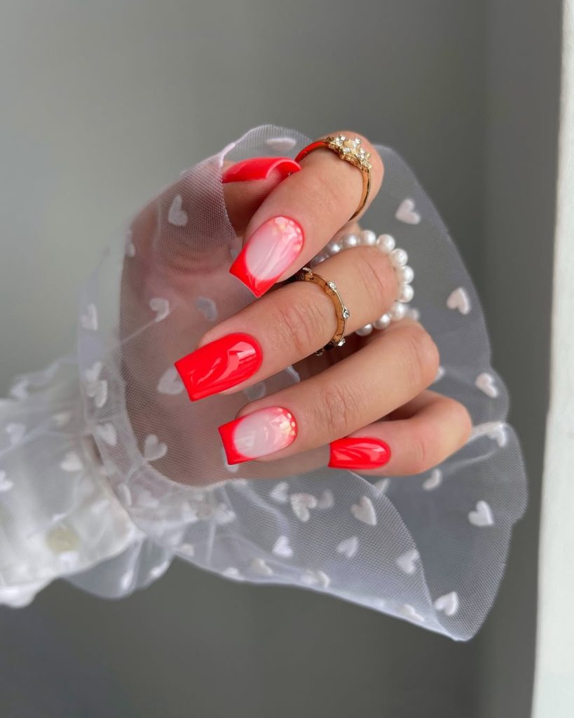 Long square neon coral nails with natural base accent nails and curved details and glitter
