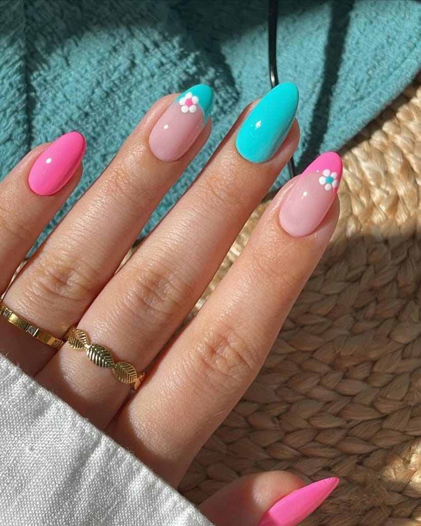 almond vacation nails with turquoise pink nude skittles and small white daisy flower accents
