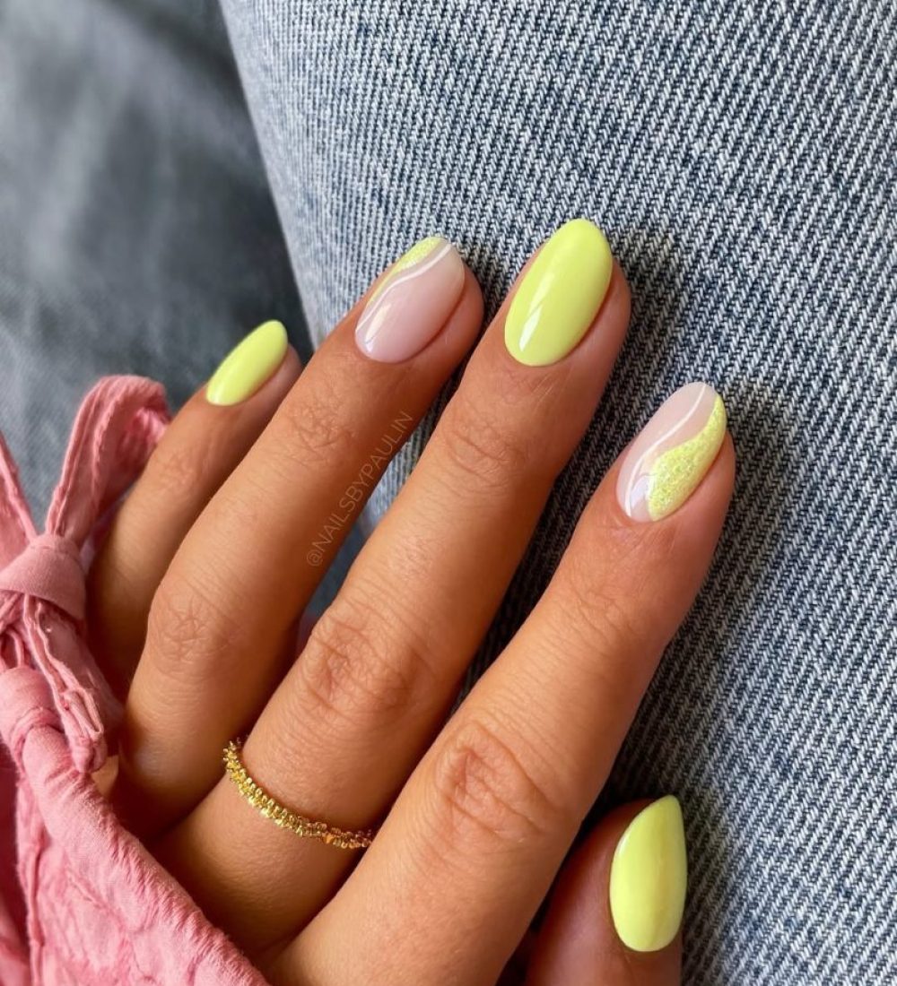 short oval July nails with bright yellow polish and milky base with yellow textured accent designs