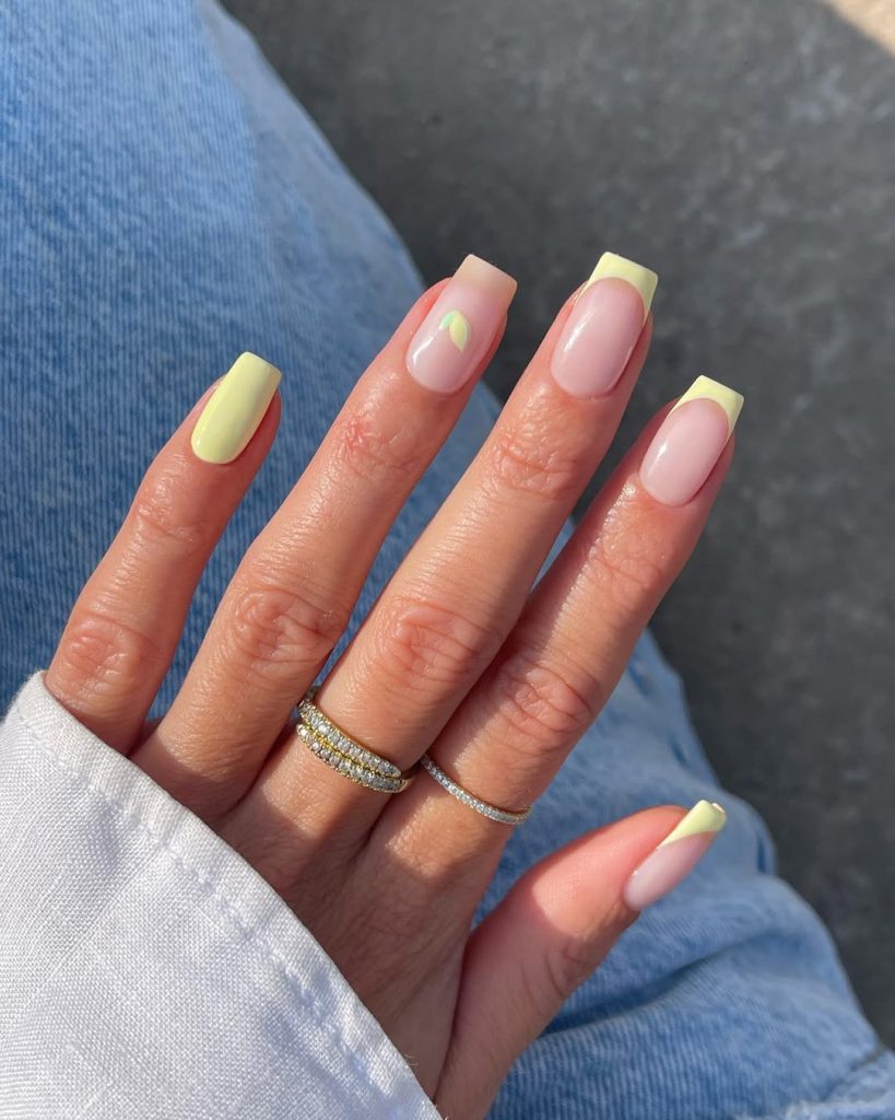 square summer nails with pastel yellow French tips, solid yellow accent nail and tiny lemon detail