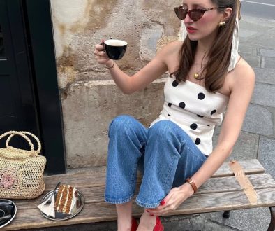 Parisian summer outfit with white and black polka dot sleeveless top, medium wash straight leg jeans, red patent mary jane heels, straw bag and tortoise sunglasses