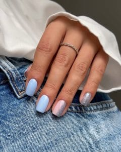 Elegant short summer nails with light blue polish and pink-to-silver glitter gradient accent nails