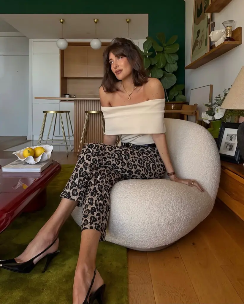 classy summer date night outfit with cream off-shoulder top, fitted leopard print pants, thin black belt and sleek black slingback heels 