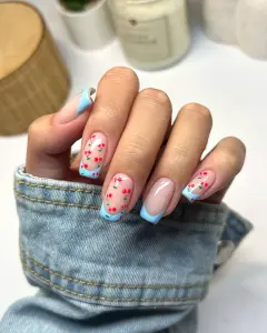 Long square summer nails with milky pink base, blue French tips, and cute red cherry designs
