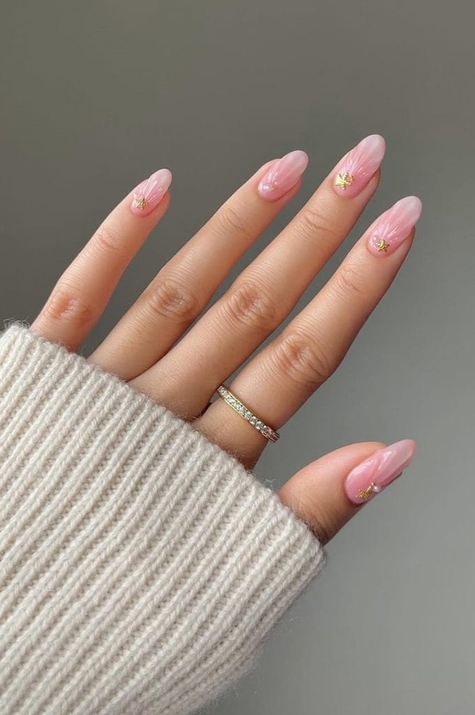 oval vacation nails with 3D pink design and small gold starfish charm accents
