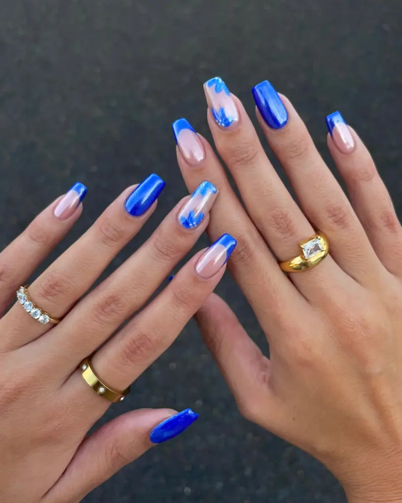 Square nails with electric blue solid, French tips, and flower accents with glazed finish