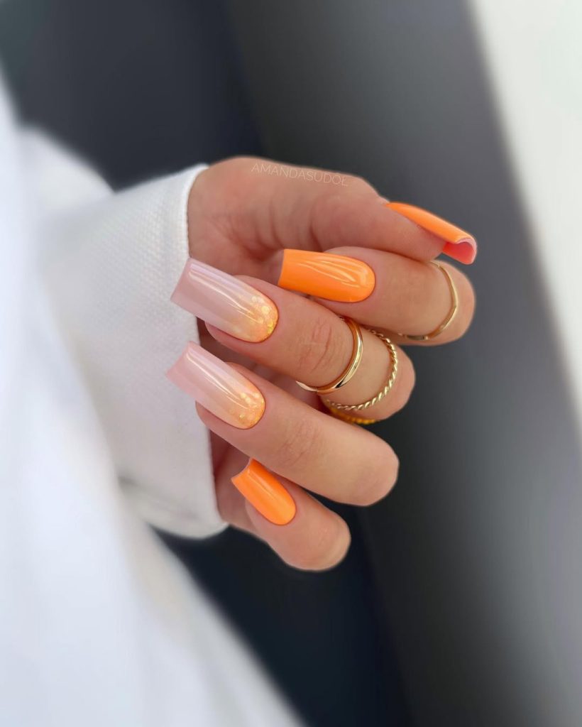 Long square nails with neon orange solid color and nude-to-orange ombré with glitter
