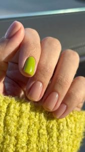 Elegant short summer nails with glossy nude polish and bright lime green accent nail
