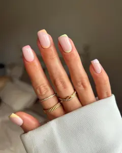  oval July nails with pink base and diagonal pastel accents along cuticles and sides in yellow, green, and purple