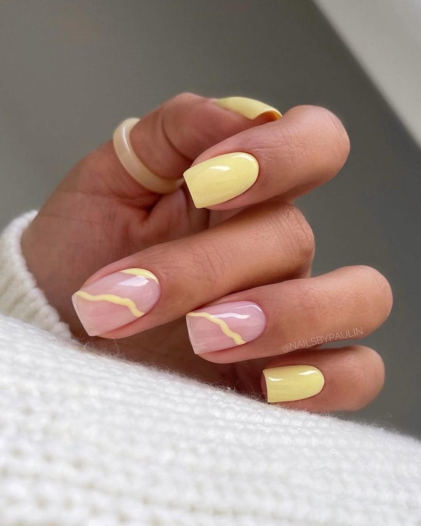 Short vacation nails with solid yellow and milky base yellow swirl design
