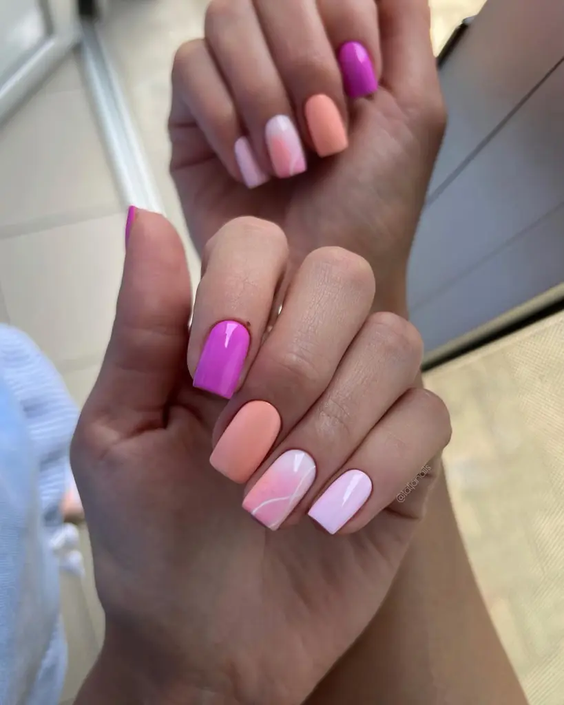 Square summer nails in skittle style with lilac, peach and magenta shades featuring pink swirl accent nail 