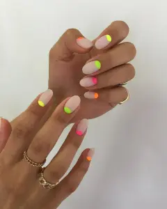 Almond nails with vibrant neon half moon cuticle designs in multiple bright summer colors on milky base