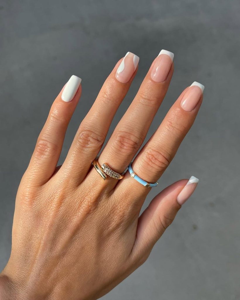old money summer nails with alternating designs - solid white, pink with white tips, and abstract white swirl on pink base