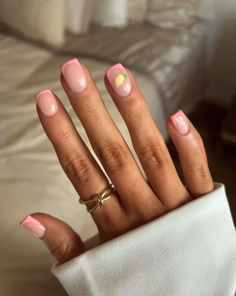 elegant short summer nails with pink French tips and cute lemon accent design
