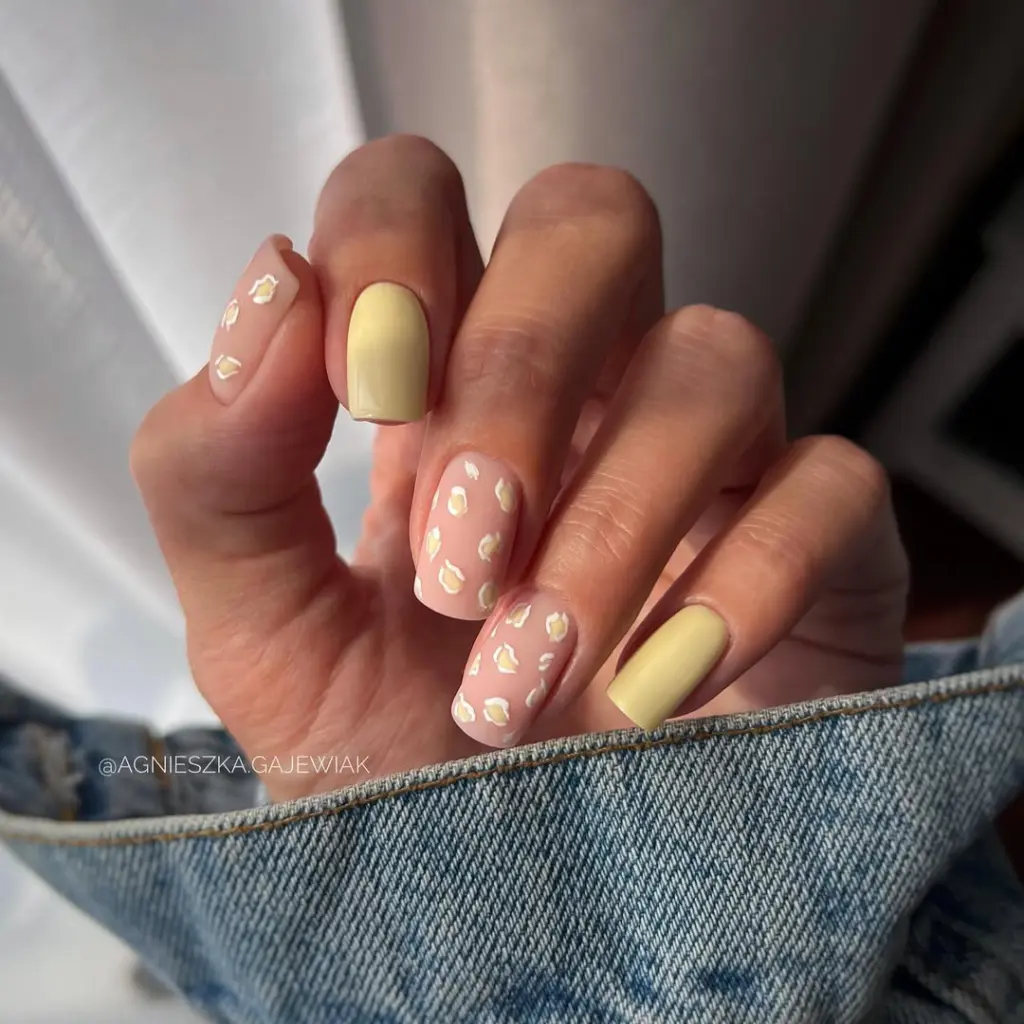 Classy short summer nails with soft yellow and pink polish featuring elegant white leopard print pattern

