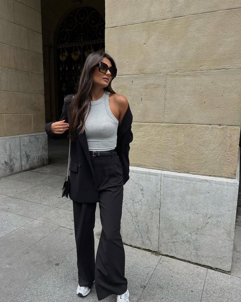 summer work outfit with black blazer, gray ribbed halter top, matching black wide-leg trousers, white sneakers and oversized sunglasses
