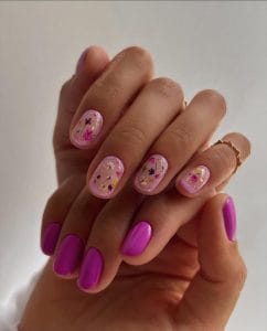 Short July nails with clear pink base containing pressed flowers and solid bright magenta accent nails