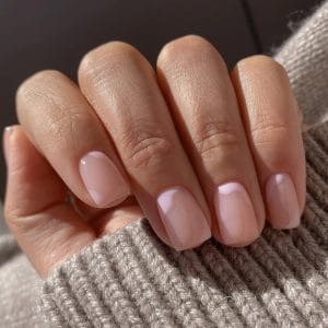 Elegant short summer nails with translucent pink polish featuring subtle white cloud-like swirl details
