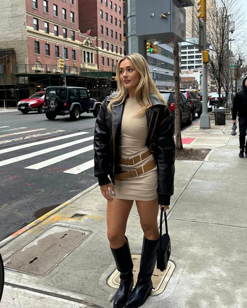 Night out outfit with black leather jacket, cream mini dress with double belt detail and black knee-high boots 
