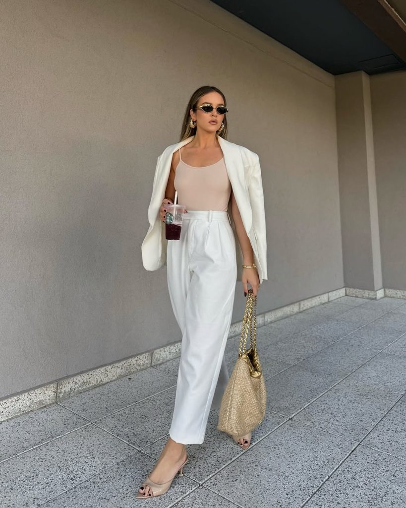 classy summer work outfit with white oversized blazer, nude bodysuit, white wide-leg trousers, raffia chain bag and nude sandals
