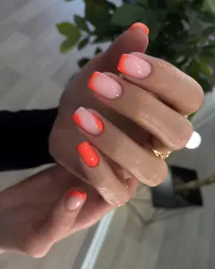 Short square nails with pink base, neon coral French tips and curved accents for bright summer style
