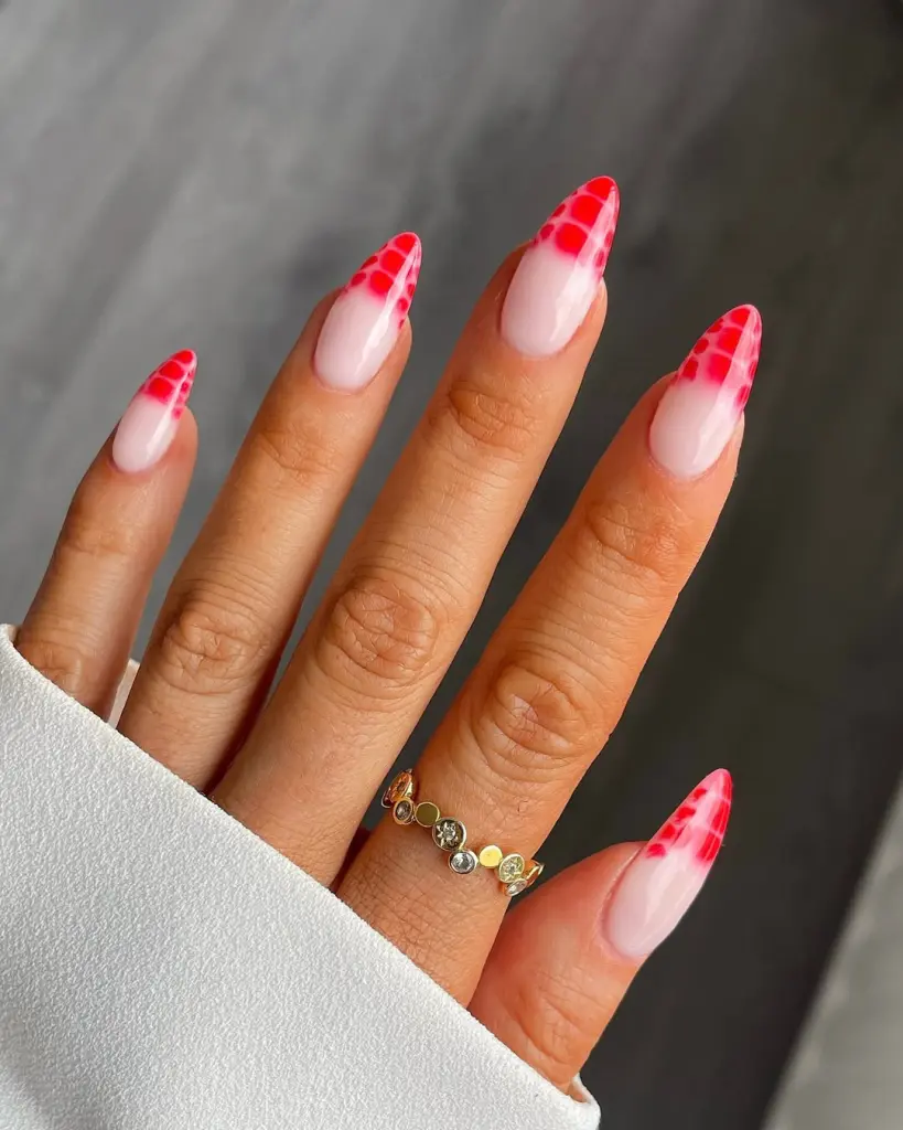 Almond shaped translucent pink nails with red snakeskin pattern at tips