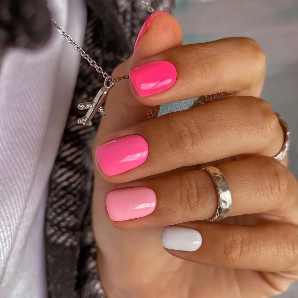Classy short summer nails with pink ombré effect from hot pink to soft blush with white accent nail