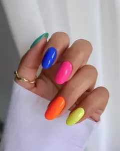 Medium oval neon skittle nails in bright rainbow colors for bold summer manicure style