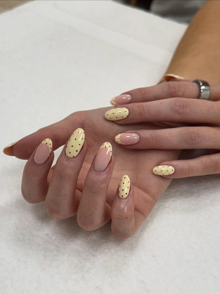 Almond simple summer nails alternating butter yellow with red dots and sheer pink with matching dots