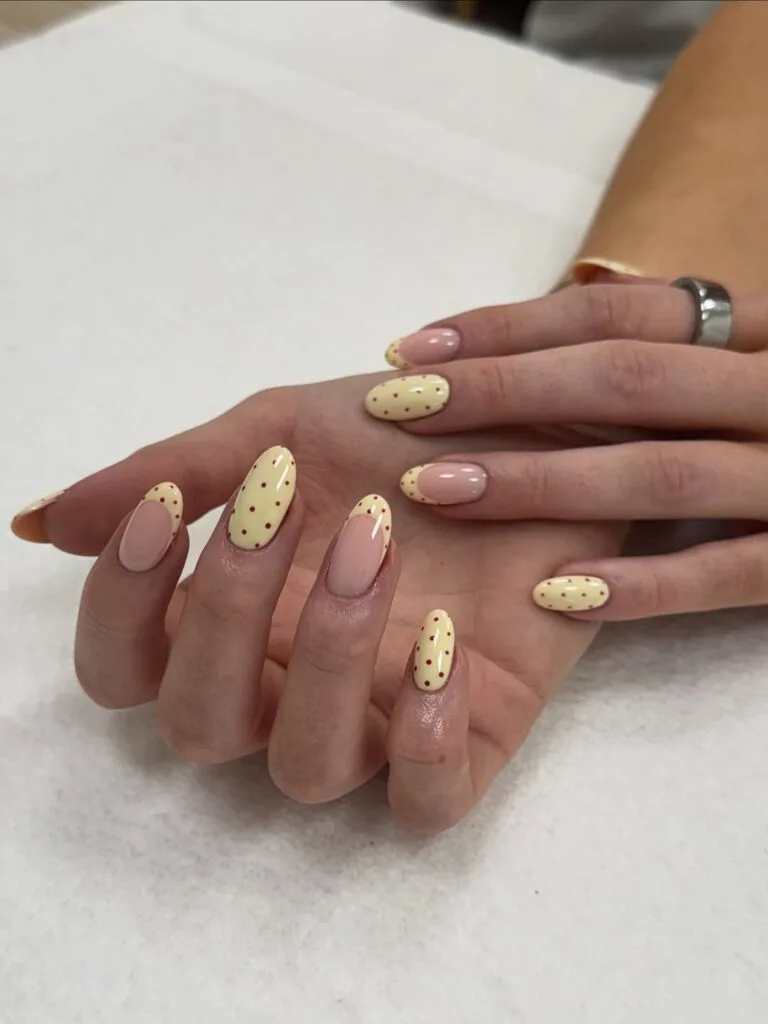 Almond simple summer nails alternating butter yellow with red dots and sheer pink with matching dots