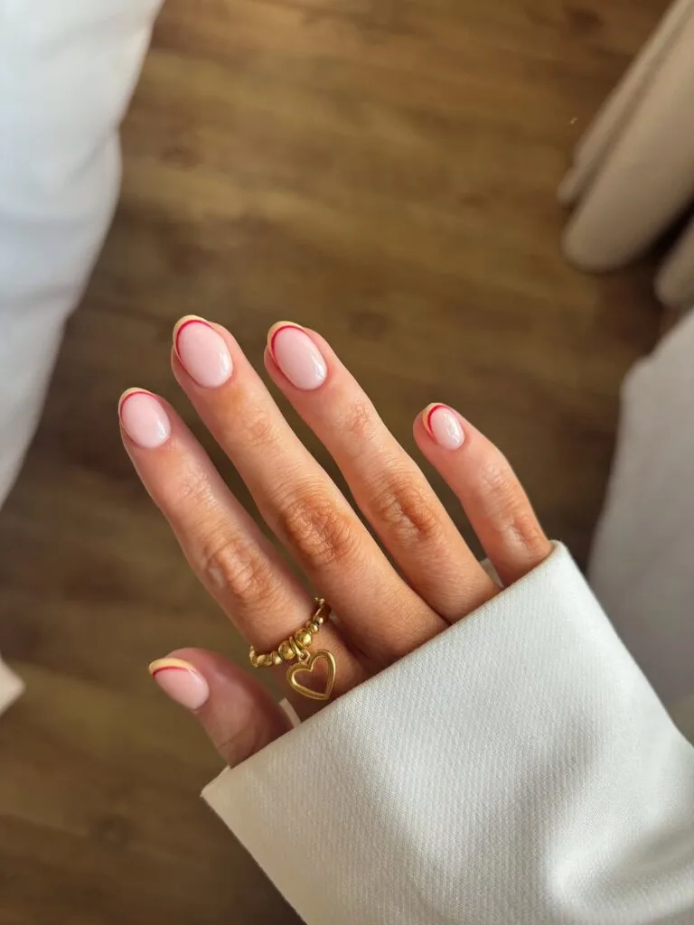 Short oval simple summer nails with warm pink base and thin fuchsia berry curved line accent near tips