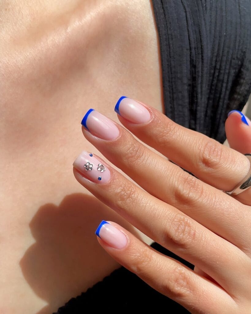 classy short summer nails, royal blue French tips on square nails with crystal flower accent
