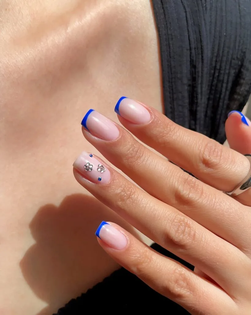 classy short summer nails, royal blue French tips on square nails with crystal flower accent
