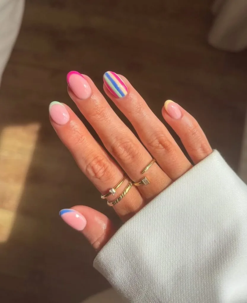 short summer nails, pastel rainbow French tips with multicolor striped accent on almond shape

